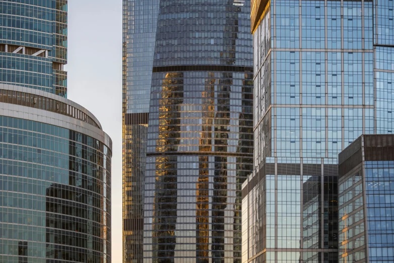 several buildings in the city and skyscrs reflected on windows