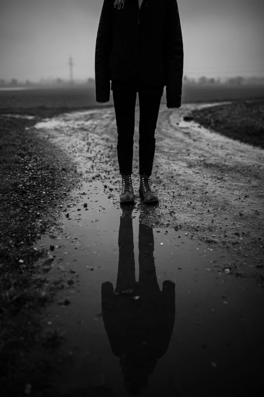 a man walking down the wet road in the snow