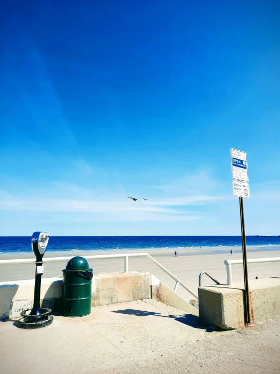 a beach that has been designated by some trash cans