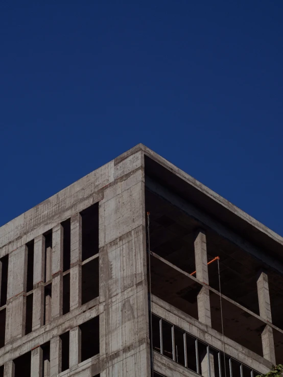 a concrete building with a clock on the top