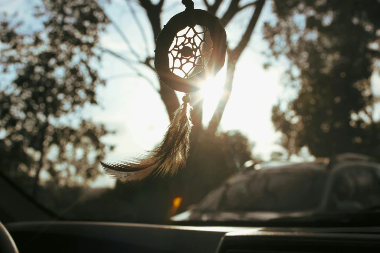 a dream catcher hanging out of the car's window