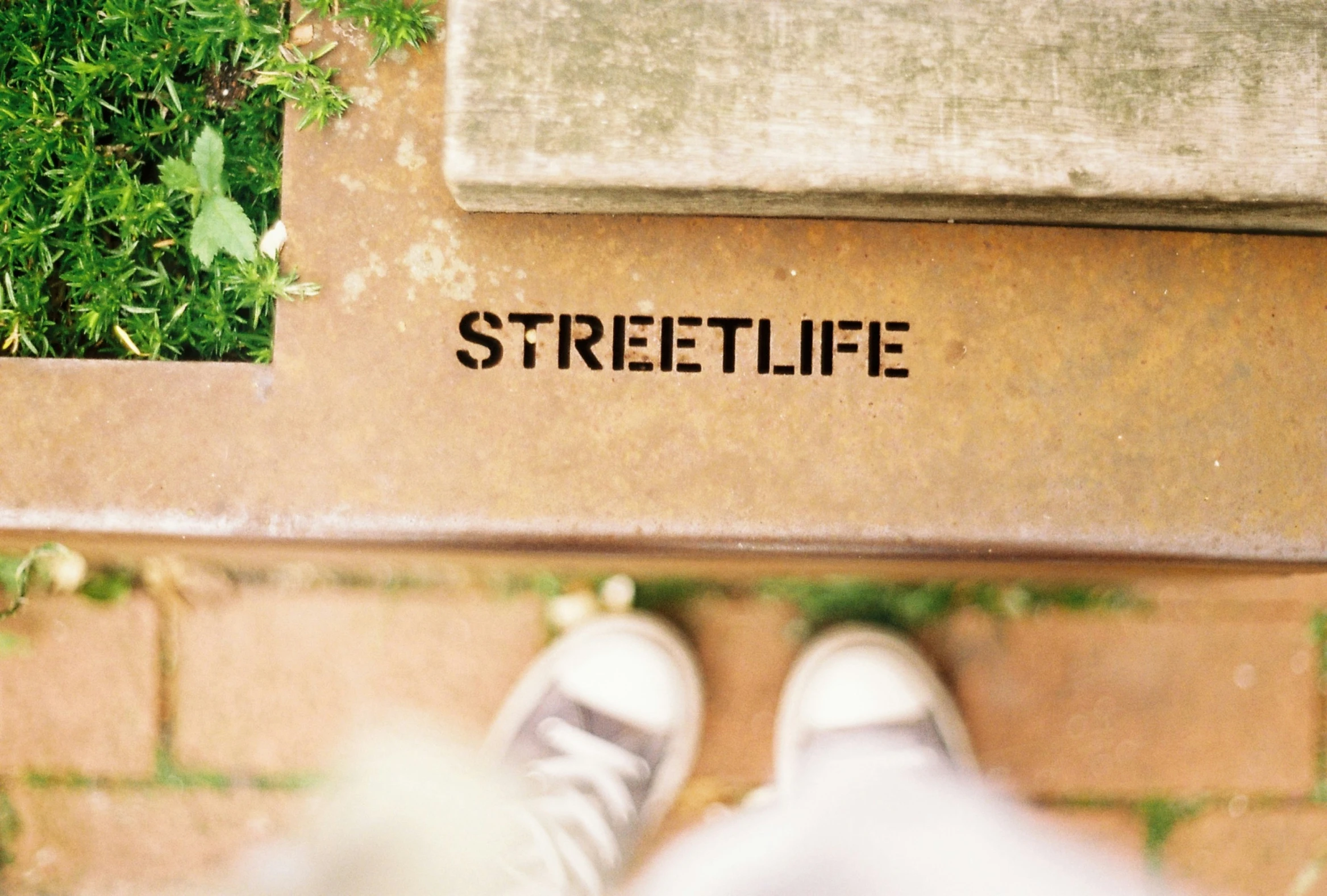 a foot is standing next to a street sign with wording