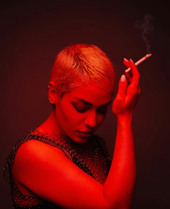a woman is holding her cigarette, and smoking a cigarette