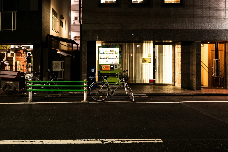 a bike parked next to a green bench outside