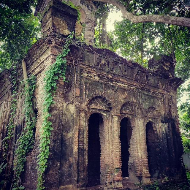 an old and broken stone structure with a tree growing over it