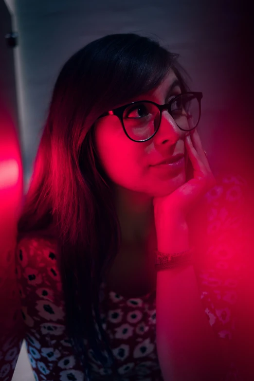 the woman with glasses is sitting and posing for the camera