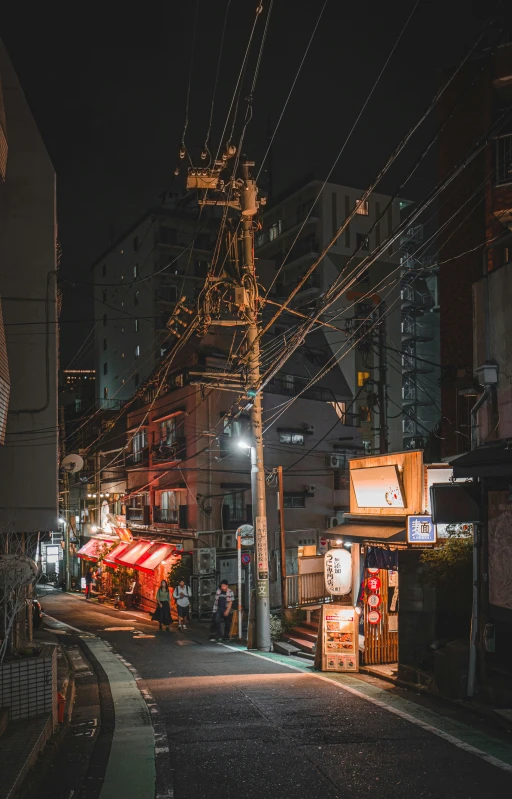 a night time street scene with telephone wires and businesses