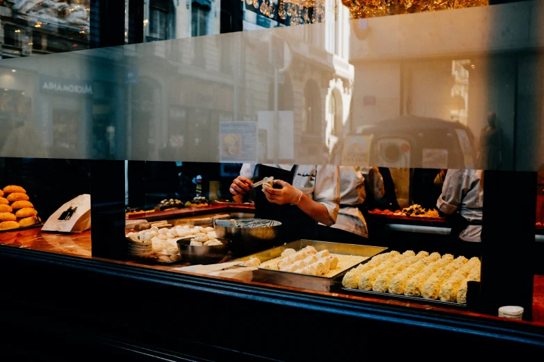 person taking a po of food in display window