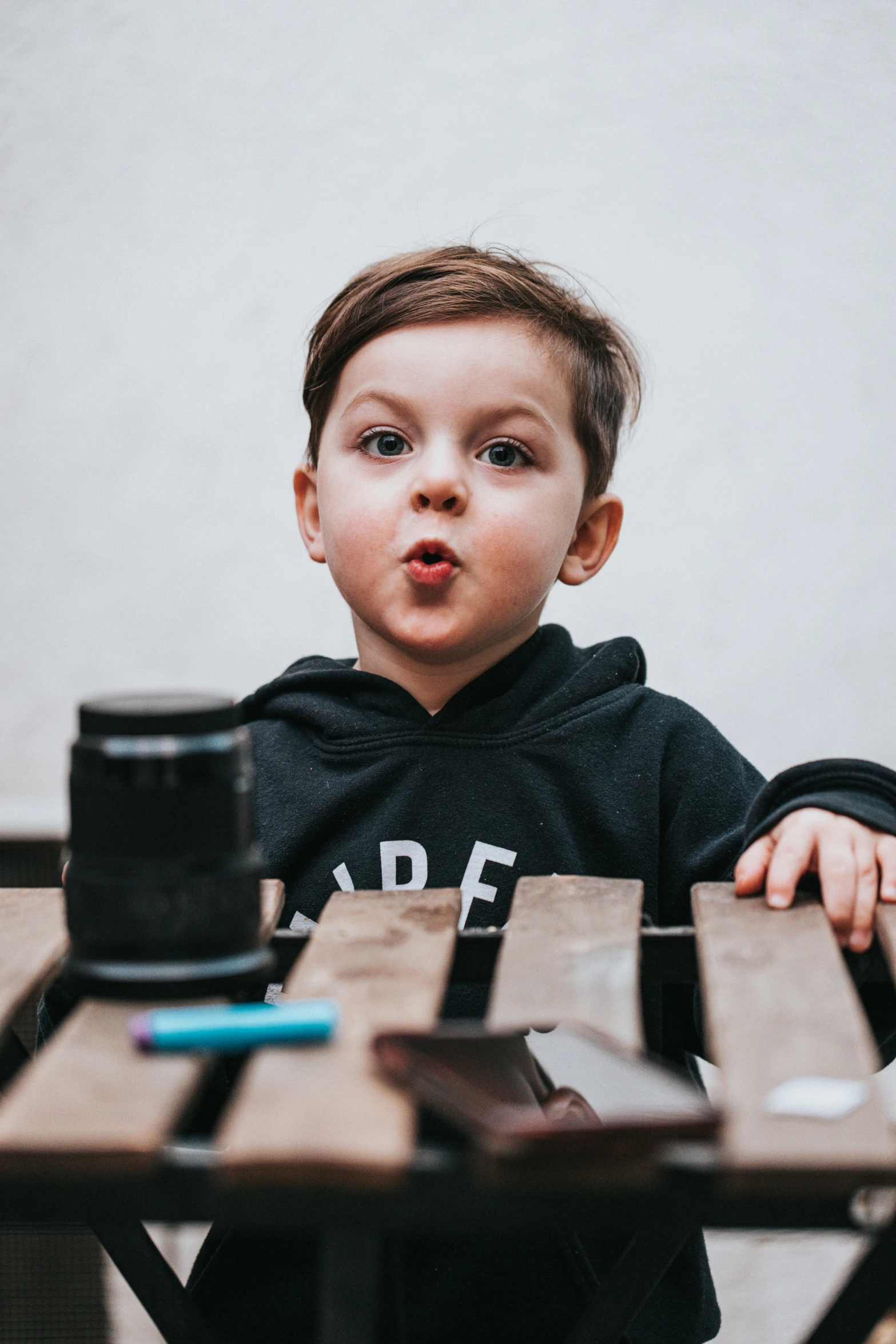 a little boy standing up in front of a table