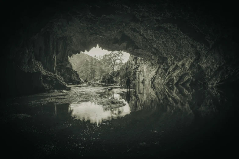 a large cave with water in it and lights on