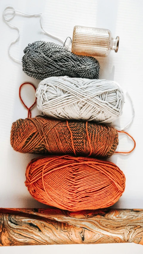 five skeins of yarn on a white background