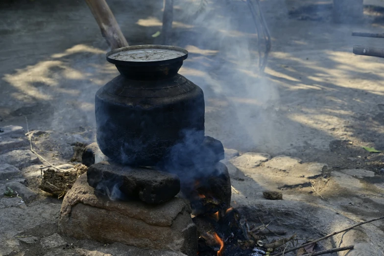 cooking a soup over an open fire, outdoors