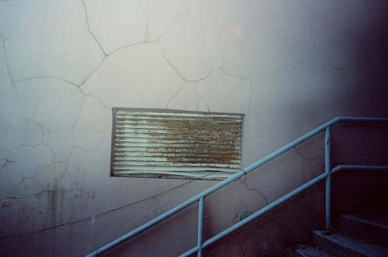 the top of a staircase and window with a blind folded