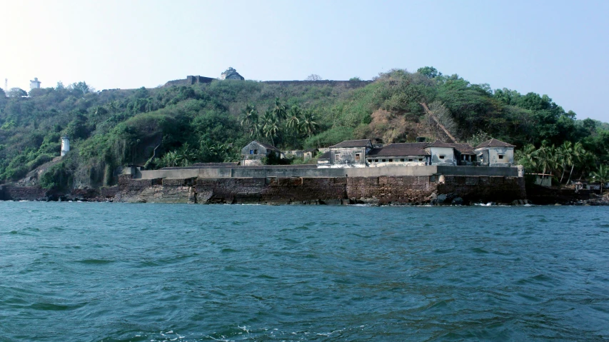 an island with houses near the water and some mountains