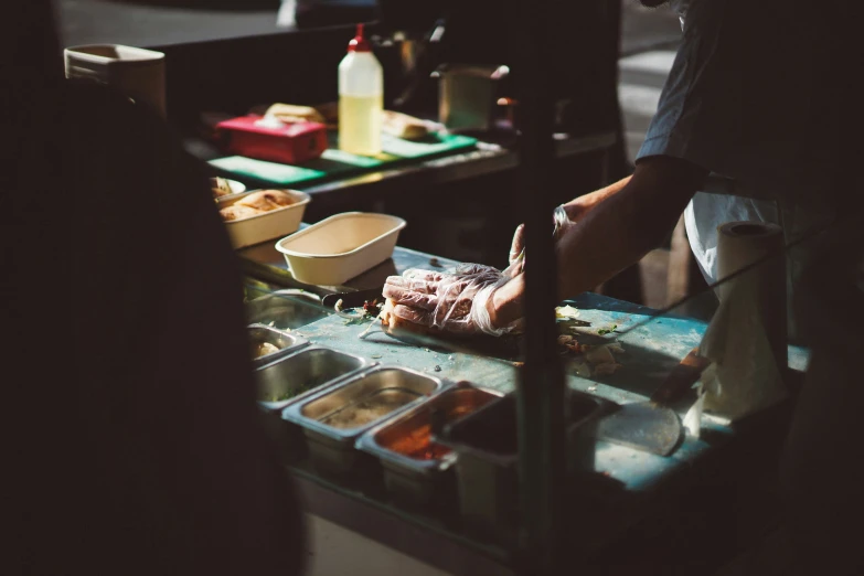 person preparing food on a glass table with containers and bowls