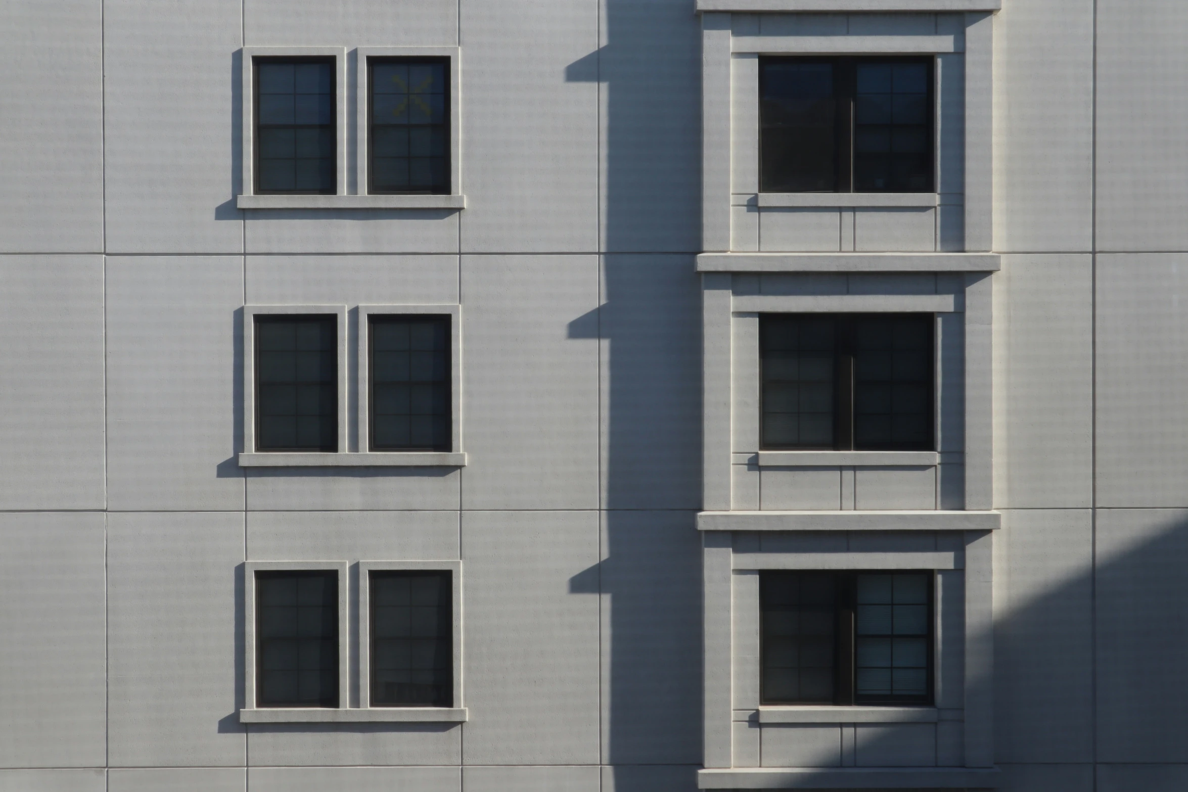 a big building with some windows and shadows on it