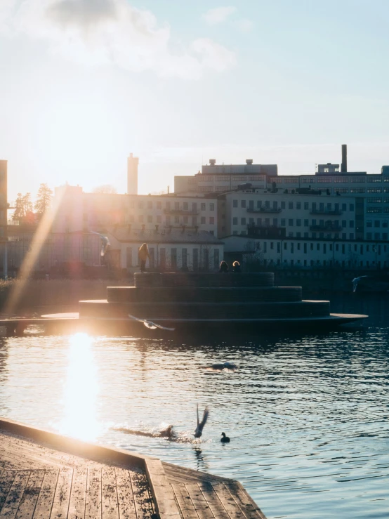 a sunset view of a boat dock with buildings in the background