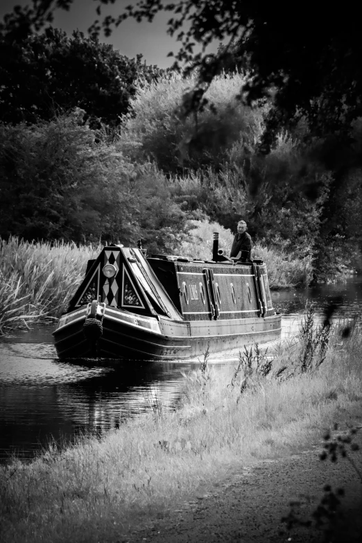 black and white po of man sitting on the back of a boat