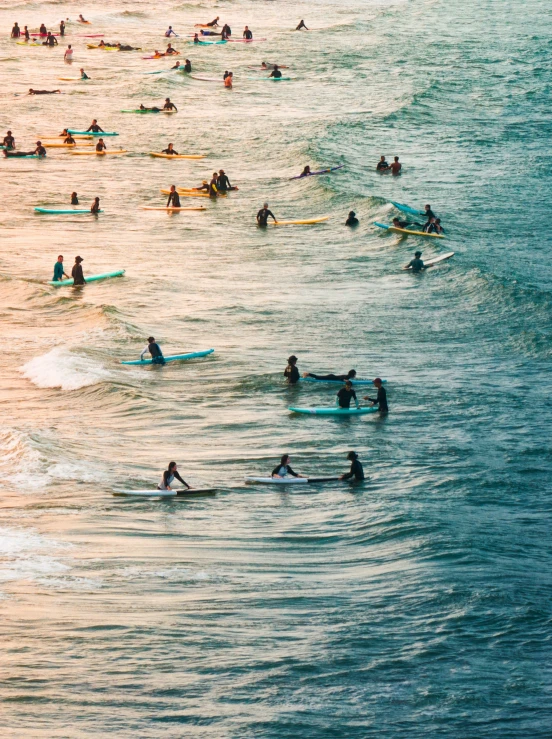 many people swimming in the ocean on their surfboards