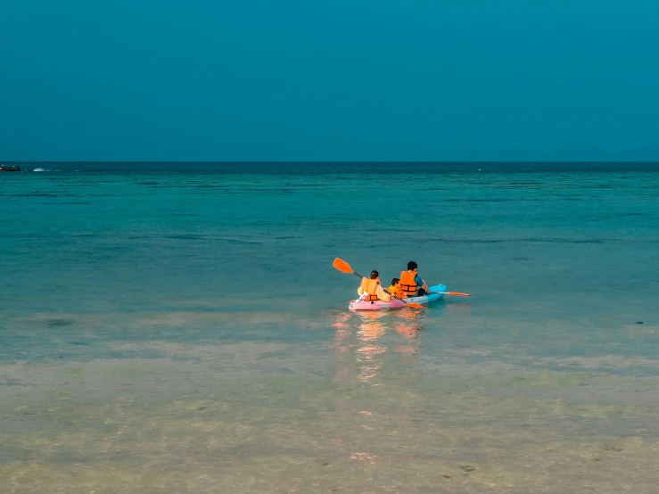 two people riding in a kayak in the water