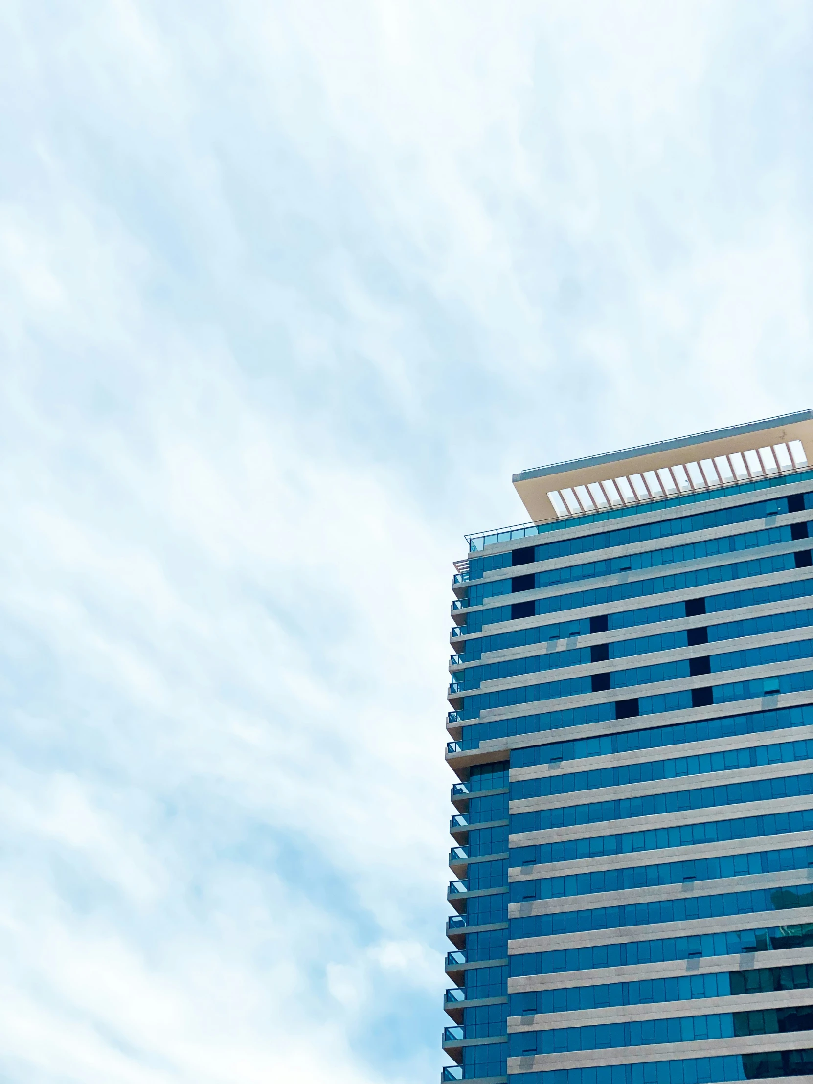 tall blue office building in a blue sky