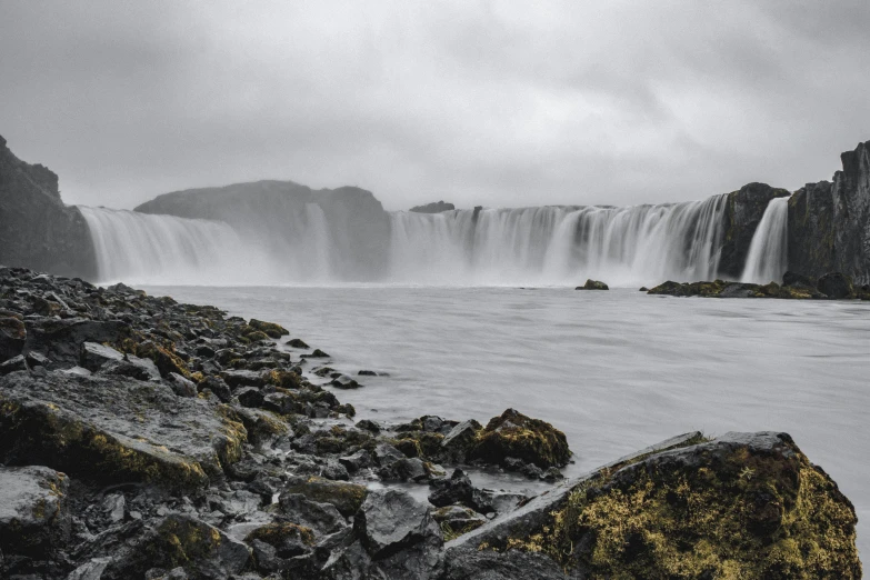 a waterfall in a lake surrounded by rocks