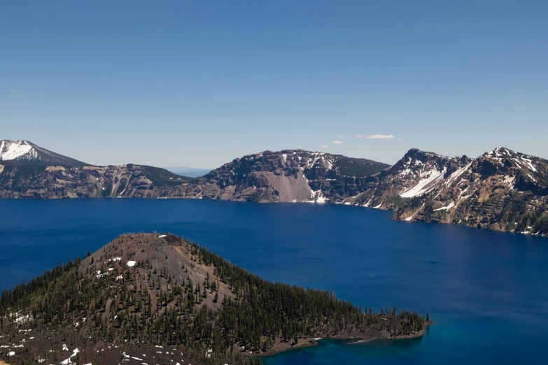 a blue lake sits at the foot of two mountain peaks