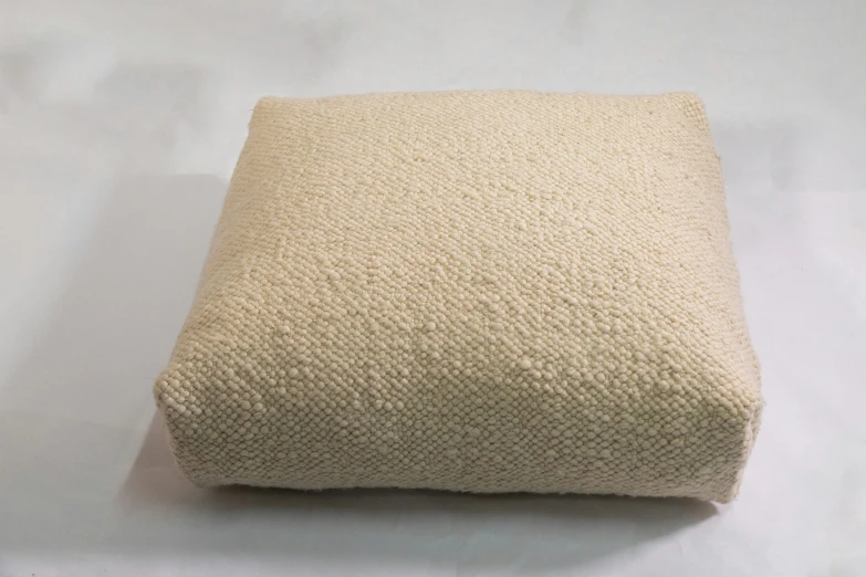 a white floor cushion sitting on top of a table