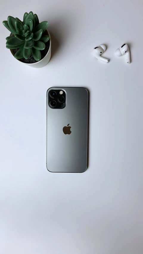 an apple iphone sitting on top of a desk next to some white letters