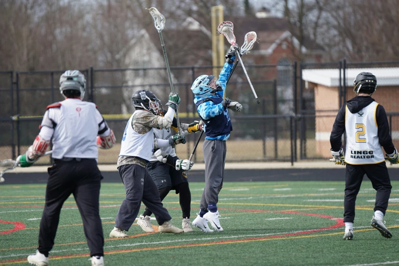 a woman holding up her lacrosse stick and another person in front holding the ball