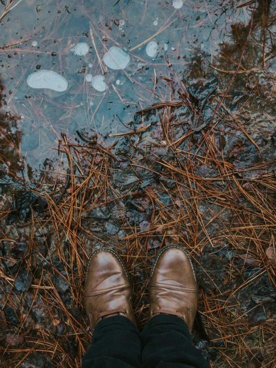 a person standing on a dirty lake surrounded by water