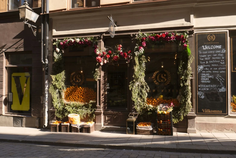 a street corner with an open sign and store front covered with hanging decorations