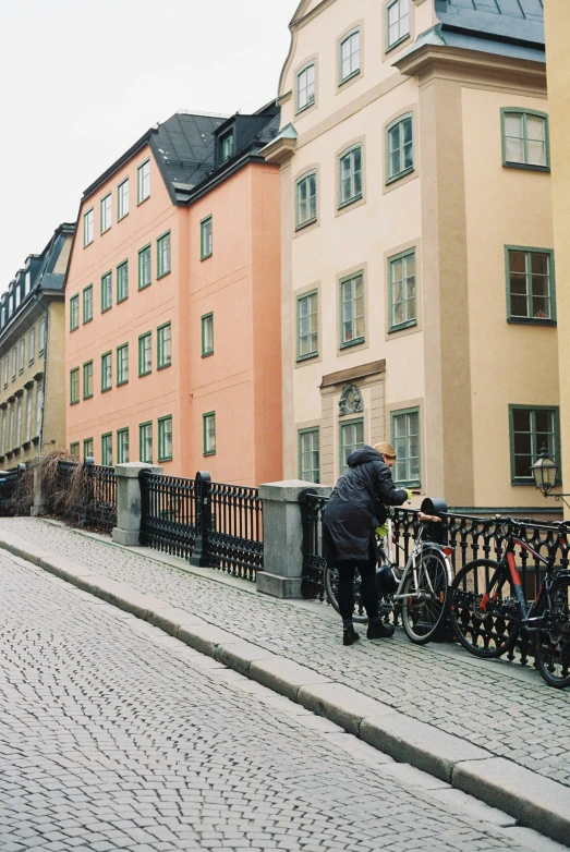 a person stands on the street next to a tall building