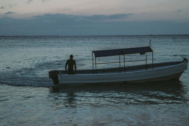 a man stands on the back of a boat