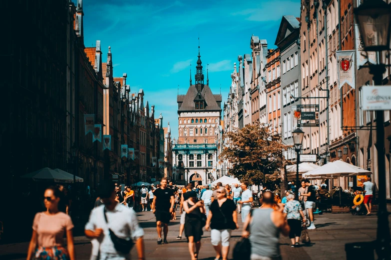 a crowd of people walking down a street next to buildings