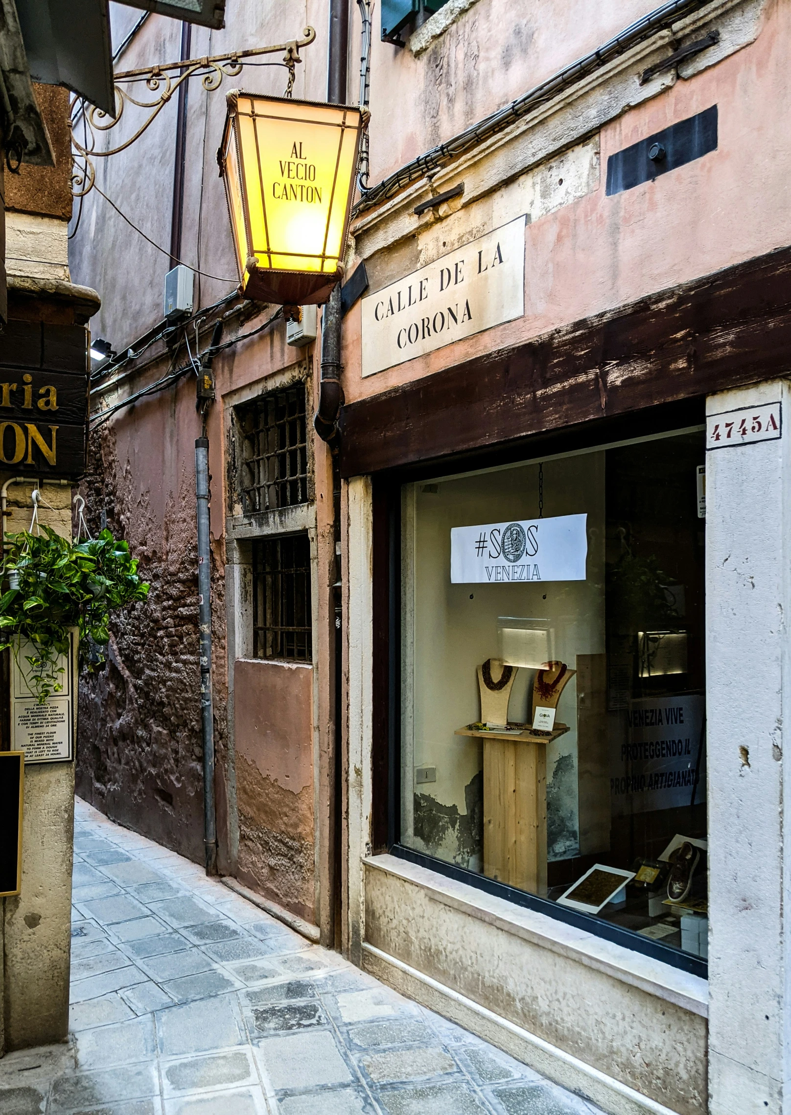 a shop front with a hanging light and vase