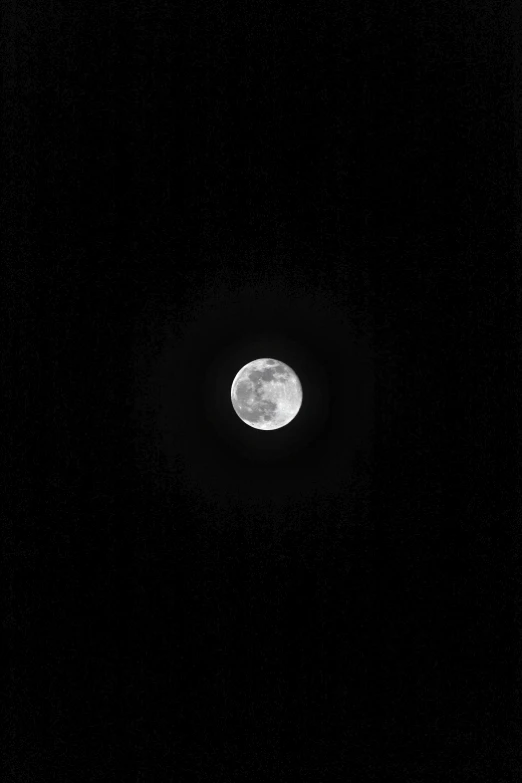 the moon seen through the dark sky in the dark of night