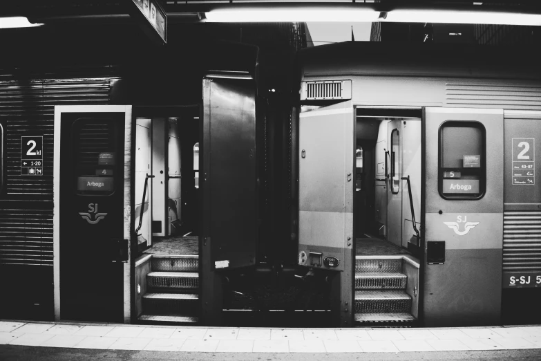 a train has been pulled up to the platform and its doors open