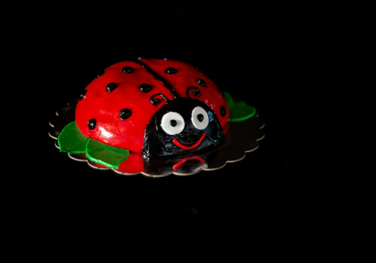 red and black cake with a lady bug on top