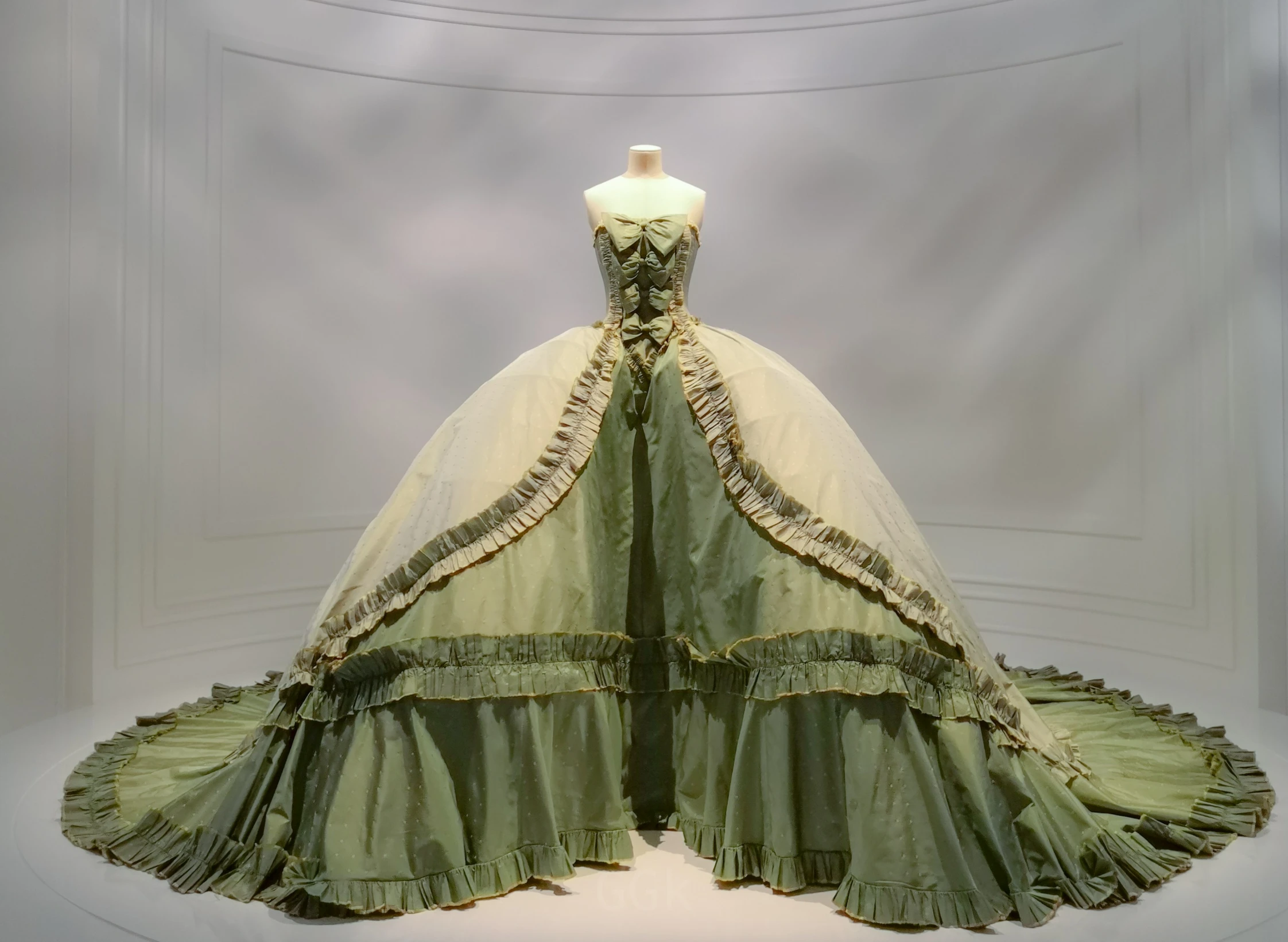 a woman's gown with large train and large skirt, made from green organes, is on display in the museum