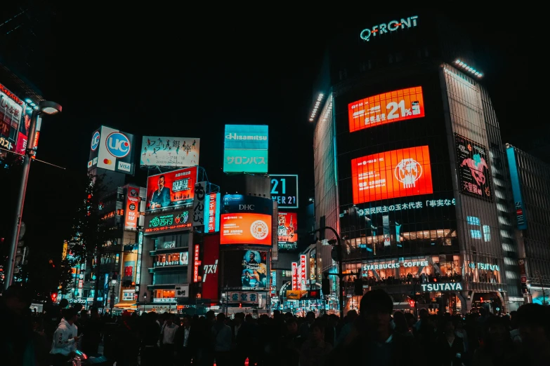 a city at night with lit up signs in the dark