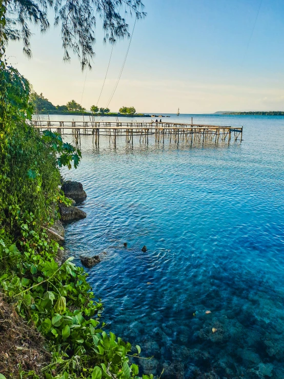 an old wood dock in front of a blue water river