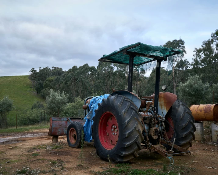 an image of a tractor with three tires in the dirt