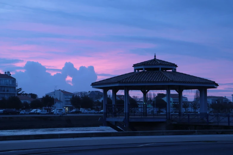 a gazebo sits on the side of the road