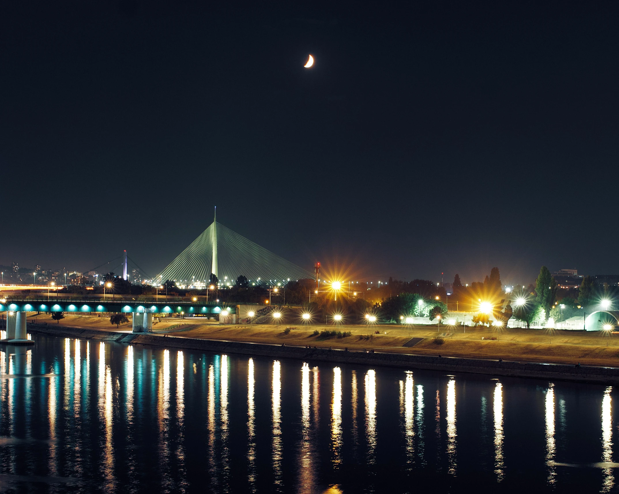 an image of a city at night with lights and reflection on the water