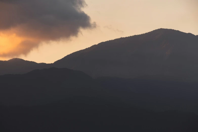 a very dark and cloudy mountain with some clouds