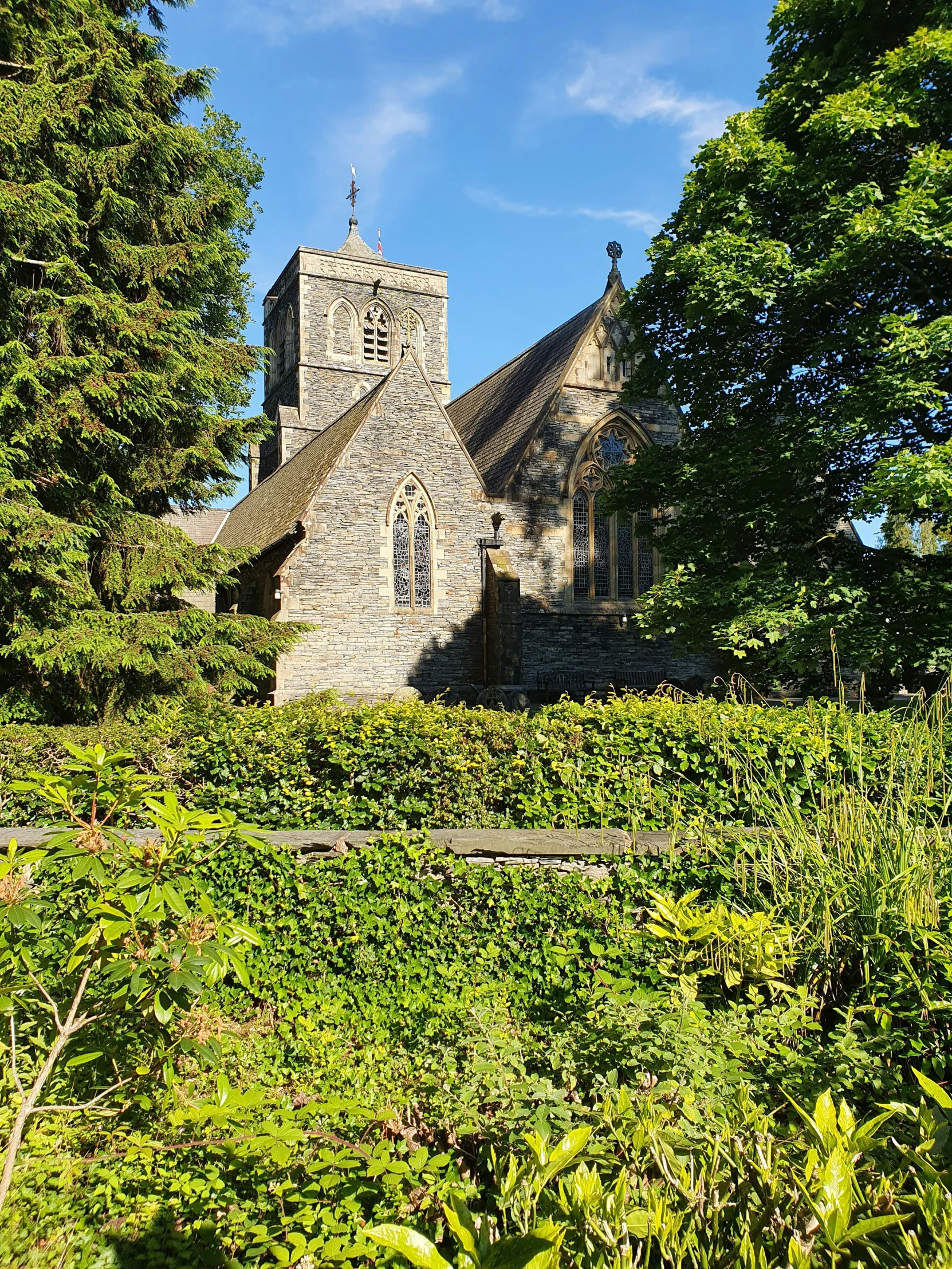 an old church surrounded by trees on the side