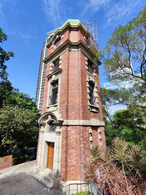 a clock tower sitting next to trees under a blue sky