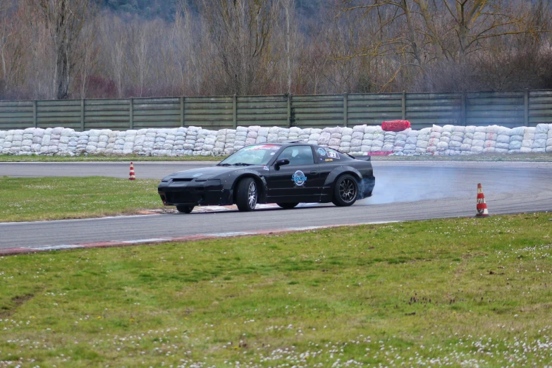 a car turning around on the racetrack during the day