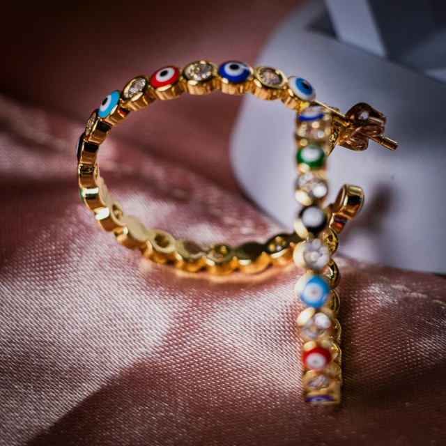 some colorful jewelry sitting on top of a fabric